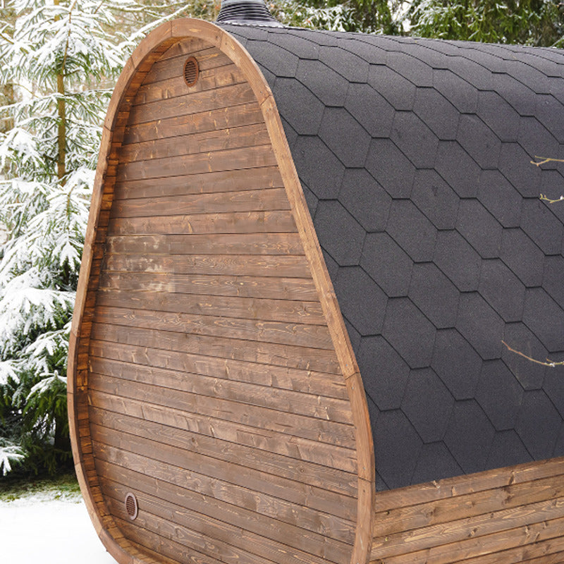 Celsium Herkus Small garden sauna in winter, rear view with black bitumen roof and snowy surroundings.